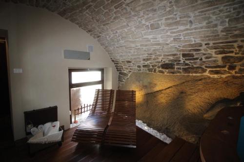 a room with a stone wall and a wooden bench at MIRUTT Relax by Keyhole Selection in Castelmezzano