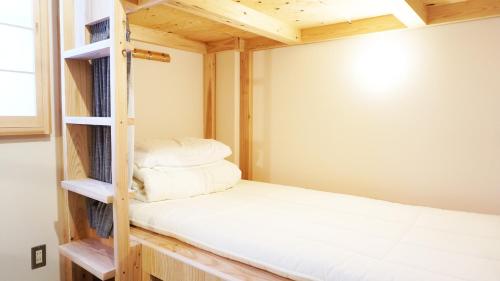 a small bedroom with a bunk bed in it at Poly Hostel 2 Namba in Osaka