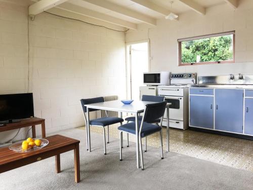 a kitchen with a table and chairs in a room at Martinborough Motel in Martinborough 