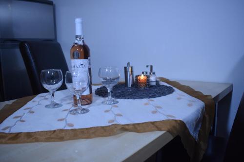 un tavolo con bicchieri da vino e una bottiglia di vino di Beška a Bešeňová