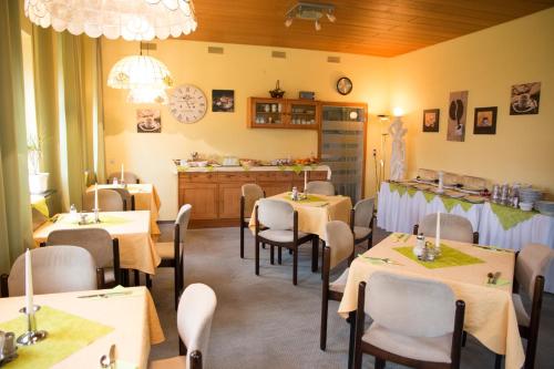 - un restaurant avec des tables et des chaises dans une salle dans l'établissement Hotel Garni Trumm, à Dillingen an der Donau