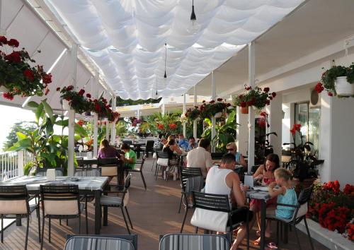 a group of people sitting at tables in a restaurant at Hotel Granit in Ohrid