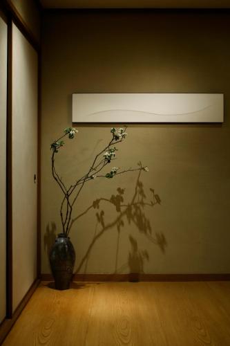 a vase with a plant in front of a wall at Takanawa Hanakohro - in Grand Prince Hotel Takanawa in Tokyo