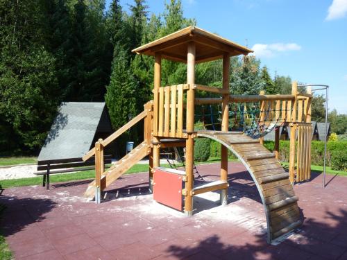 a wooden playground with a slide and a gazebo at ****FH Blauvogel 60 Harz in Hasselfelde