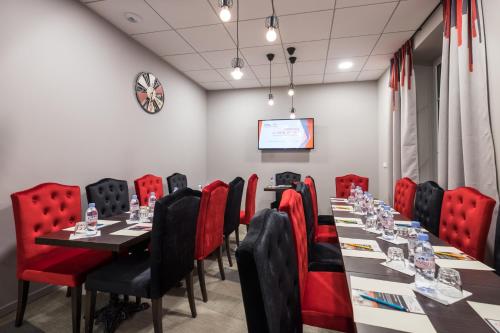 a conference room with a long table and red chairs at Hotel Victoria Lyon Perrache Confluence in Lyon