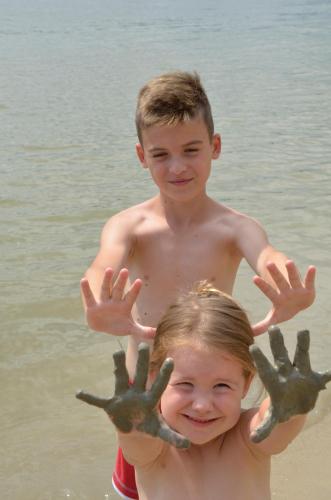 two children standing on the beach with their hands in the water at TOBO house along the river Danube in Radvaň nad Dunajom