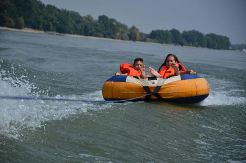 a man and a woman in an orange raft on the water at TOBO house along the river Danube in Radvaň nad Dunajom