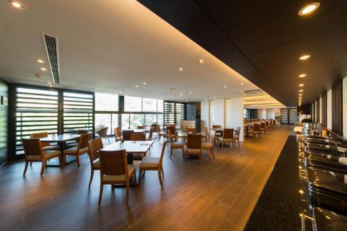 a dining room with tables and chairs and windows at Asia Pacific Hotel Beitou in Taipei