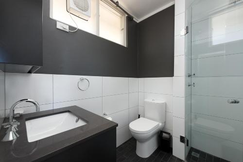 a bathroom with a toilet and a sink and a shower at Stunning Ocean View Apartment !!! in Sydney