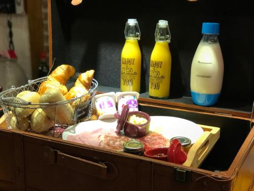 a suitcase with a basket of food and bottles of milk at Au chalet d'Isa in Havelange