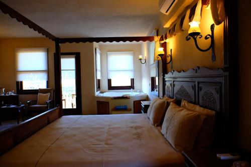 a bedroom with a large bed and two windows at Mandarin & Mango Boutique Hotel in Faralya