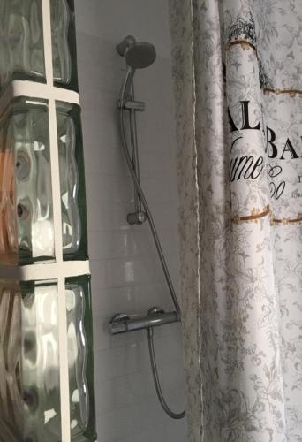 a shower head in a bathroom with a shower curtain at Cozy Townhouse Altea in Altea
