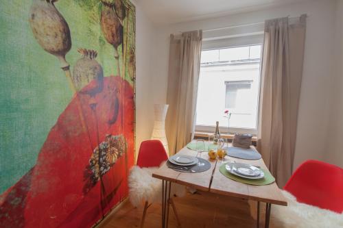 ein Esszimmer mit einem Tisch und einem großen Gemälde in der Unterkunft Wohnen an der Juliuspromenade Stadt in Würzburg