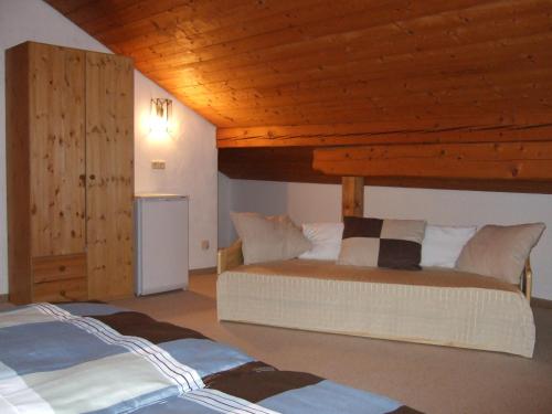 a bedroom with two beds and a wooden ceiling at Gästehaus Banik in Seebruck