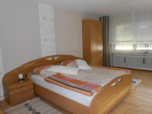 ein Schlafzimmer mit einem Bett mit einem Kopfteil aus Holz in der Unterkunft Balles in Ellenz-Poltersdorf