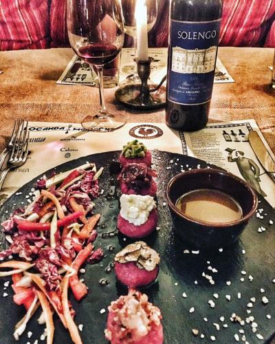 a plate of food and a glass of wine on a table at Locanda le Monache in Camaiore
