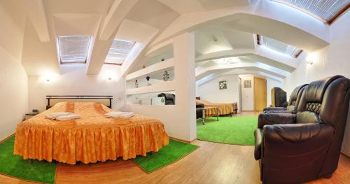 a bedroom with a large bed and two chairs at Hotel Slavia in Nizhny Novgorod