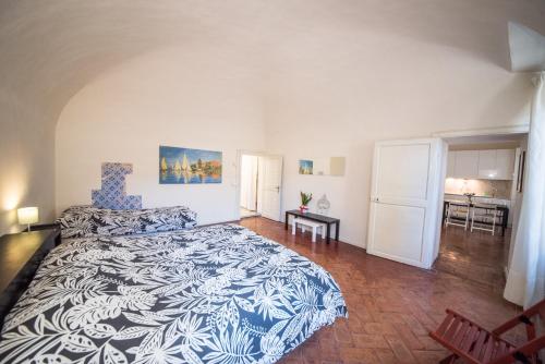 um quarto com uma cama grande e um cobertor azul e branco em Appartamento i Priori em Volterra