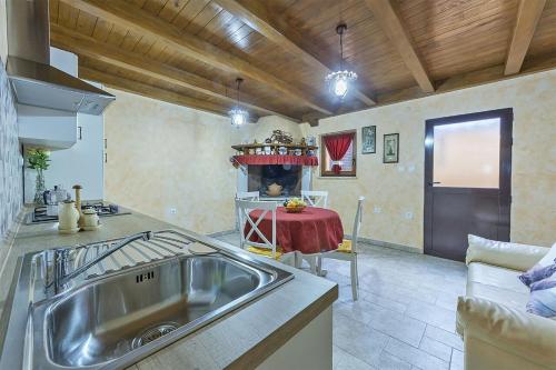 eine Küche mit einem Waschbecken und einem Tisch in der Unterkunft Apartments Monte Grande in Pula