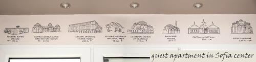 a wall with drawings of churches and mosques at The North Tower Apartment in Sofia