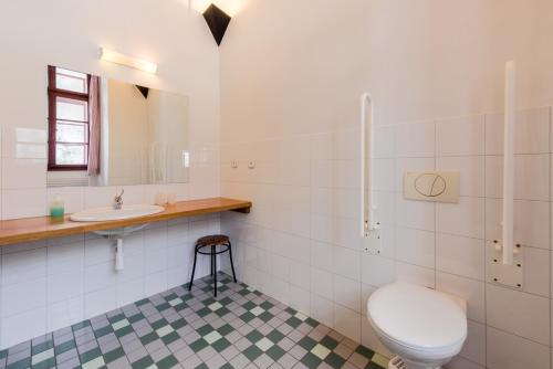 a white bathroom with a toilet and a sink at HolidayPark Mlázovy in Kolinec