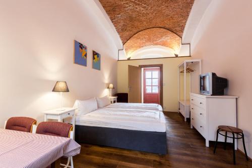 a bedroom with a bed and a tv in it at HolidayPark Mlázovy in Kolinec