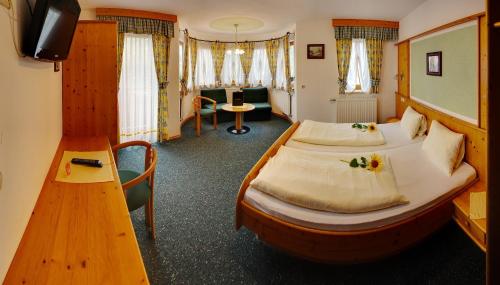 a hotel room with a large bed and a desk at Ferienhotel Innviertel in Kirchheim im Innkreis