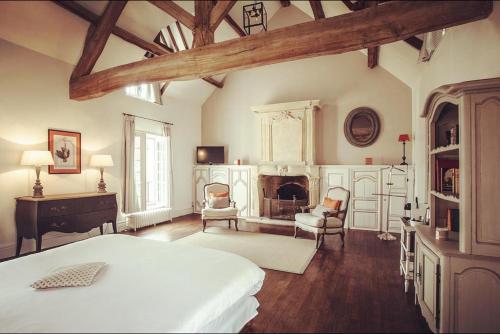 - une chambre avec un lit, des chaises et une cheminée dans l'établissement Les Hautes Sources - Esprit de France, à Ménilles
