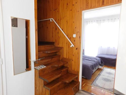 ハイドゥソボスローにあるIBI Apartmanの木の壁の部屋の階段