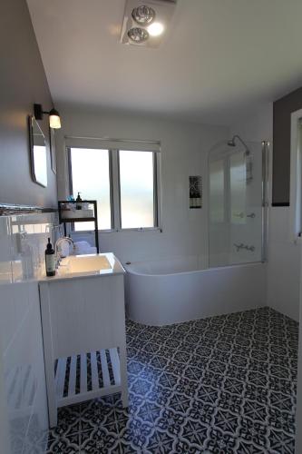 a bathroom with a tub and a sink and a shower at Gridley Homestead B&B in Eumundi