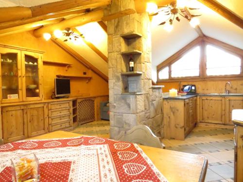 a kitchen with a table and a stone stove at Apartments & Rooms MyHolidayLivigno in Livigno
