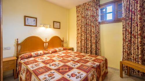卡亞俄薩爾瓦赫的住宿－藍海卡亞俄花園公寓，一间卧室设有一张床和一个窗口