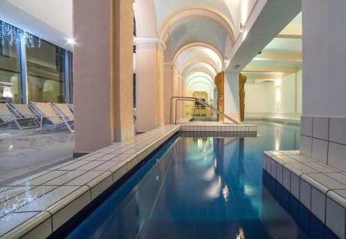 a swimming pool in a building with blue water at Grand Hotel Rogaška Premium in Rogaška Slatina