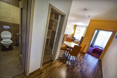 a bathroom with a toilet and a table and chairs at Crocus Apartments 310, 507 in Štrbské Pleso