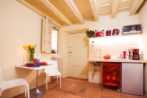 a small kitchen with a table and a sink at Suite Viola Antica in Lucca