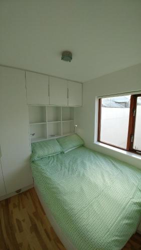 - une petite chambre avec un lit et une fenêtre dans l'établissement The Grand Canal Dock Apartment, à Dublin