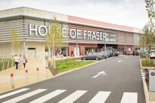 a store front of a building with a parking lot at Garfield House, 3 bed house, sleeps 7, Nr Rushden Lakes, allocated parking, corporates welcome in Wellingborough