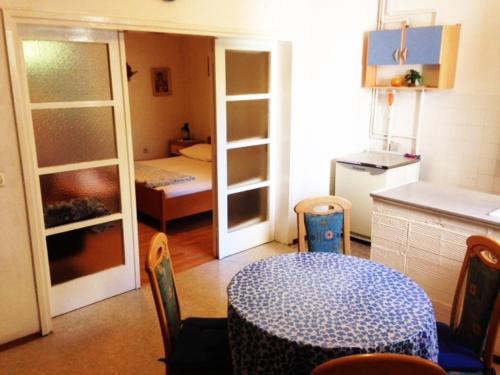 a kitchen with a table and a room with a bedroom at Apartman Gracin in Primošten