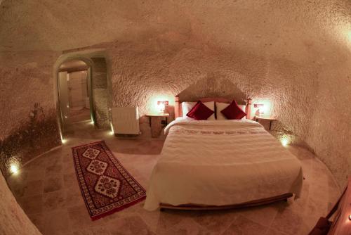 a bedroom with a bed in a stone room at Mosaic Cave Hotel in Göreme