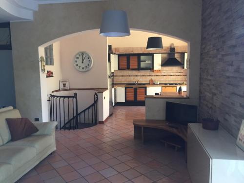 a living room with a couch and a clock on the wall at La Villa Del Cedro in Monza