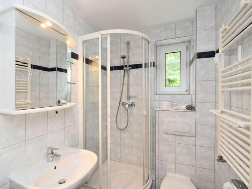 a white bathroom with a shower and a sink at Ferienwohnung-8-3 in Baabe