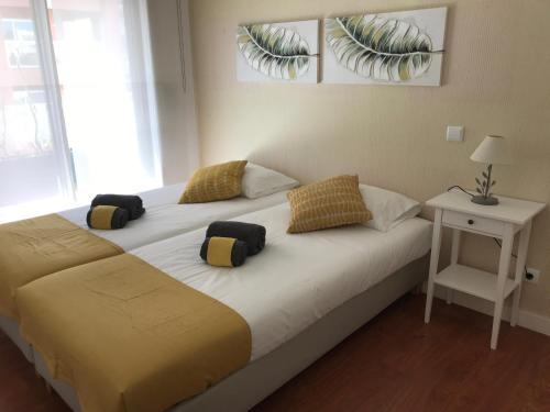 um quarto com uma cama com duas almofadas em Apartamento T&T Ocean - Foz Palace Residence Spa em Portimão