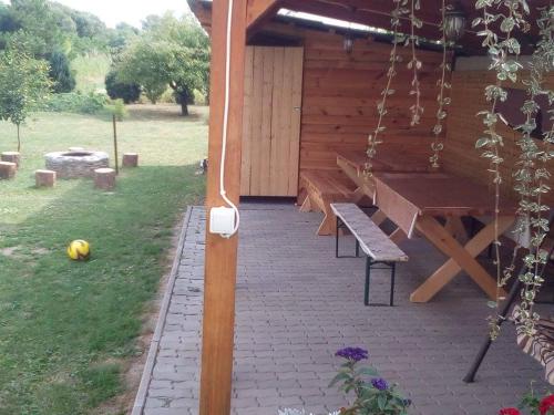a picnic table and a bench on a patio at Éva vendégház in Egerszalók