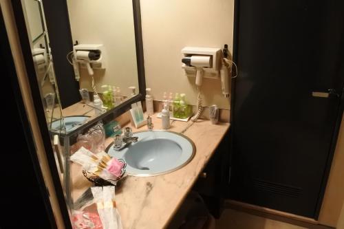 een badkamer met een wastafel en een spiegel bij Hotel Dressy (Adult Only) in Himeji