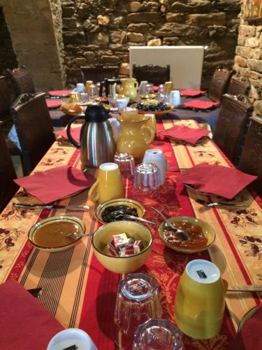 a table with a red table cloth with a tea pot on it at Château de Colombières sur Orb in Colombières-sur-Orb