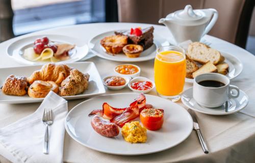 a table with plates of breakfast foods and orange juice at Kinsale Hotel & Spa in Kinsale