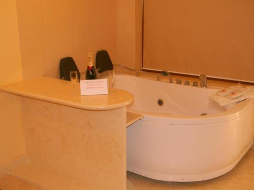 a bath room with a tub and a sink and a tub at Hotel La Scoica Land in Mamaia Nord