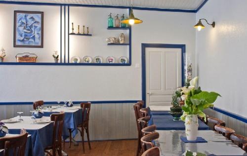 a dining room with tables and chairs in a room at Hotel Magne in Saurier