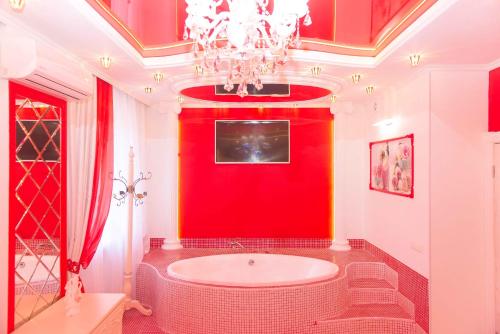 ウスリースクにあるFlagmanの赤いバスルーム(バスタブ、シャンデリア付)