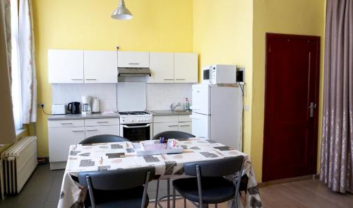 una cucina con tavolo, sedie e frigorifero di Apartments Marco Polo Midi a Bruxelles